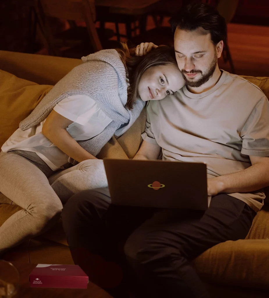 Pareja disfrutando una noche de película con la caja DulceMundo, ideal para compartir chocolates y arte de a dos.
