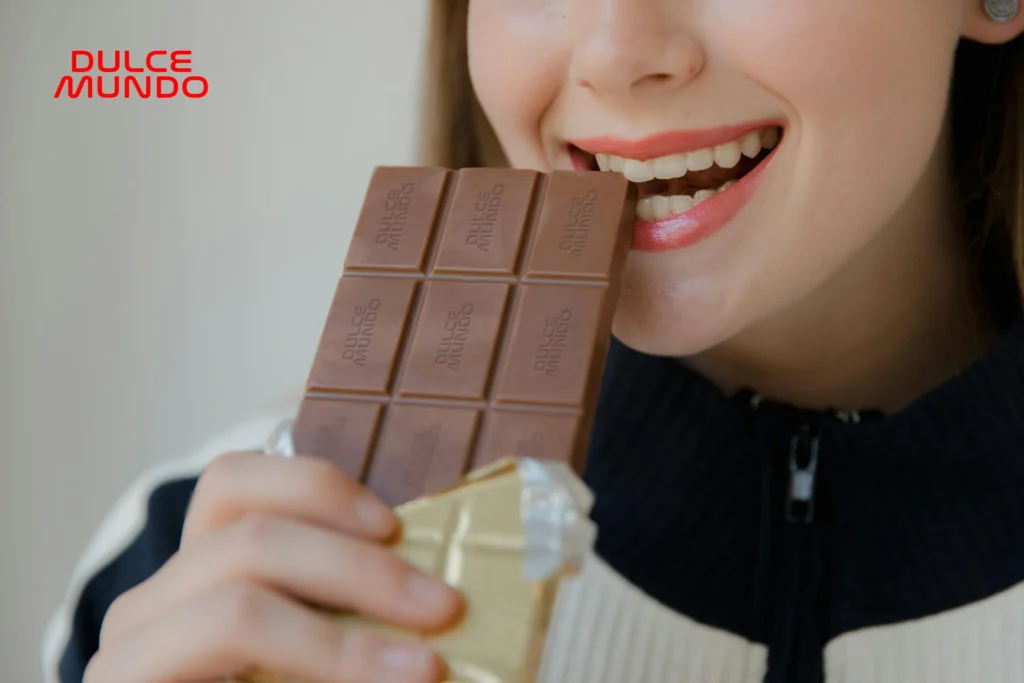 Mujer mordiendo un chocolate de la caja DulceMundo, un gusto personal con dulzura y creatividad.